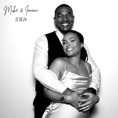 Black-and-white photo of Mike and Imani embracing and smiling on their wedding day, taken in a photo booth at a Mississauga event on December 18, 2024.