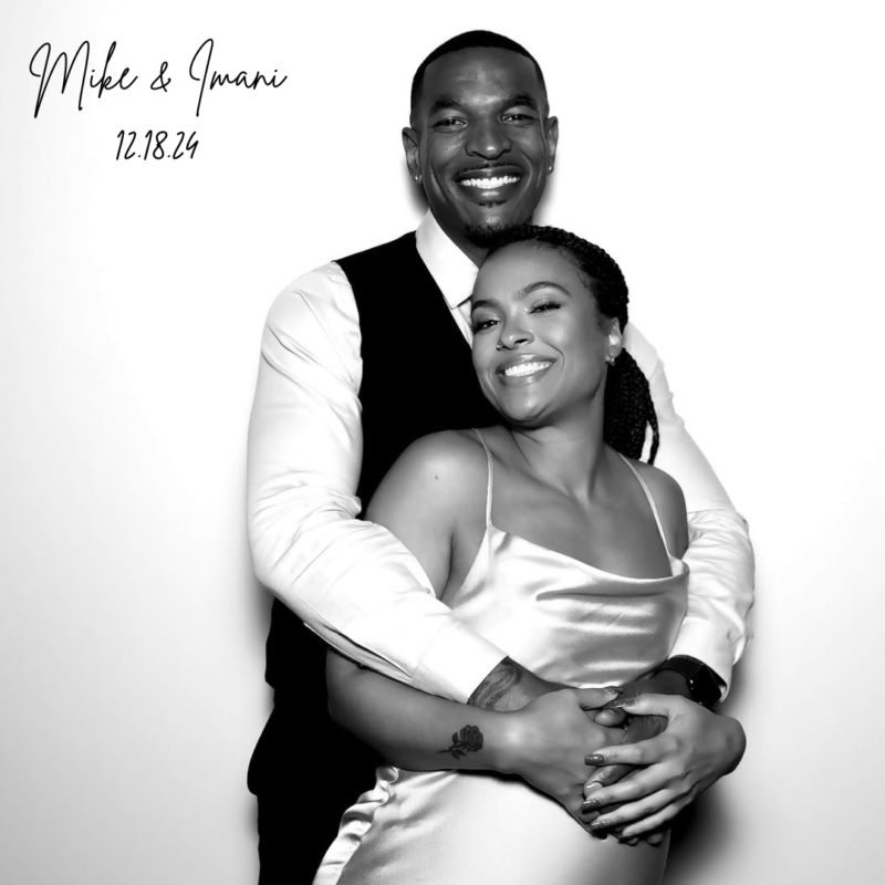 Black-and-white photo of Mike and Imani embracing and smiling on their wedding day, taken in a photo booth at a Mississauga event on December 18, 2024.