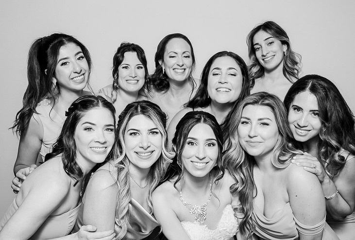 Bride and bridesmaids smiling in a black-and-white group photo at an Toronto wedding, captured in a classic photo booth style.